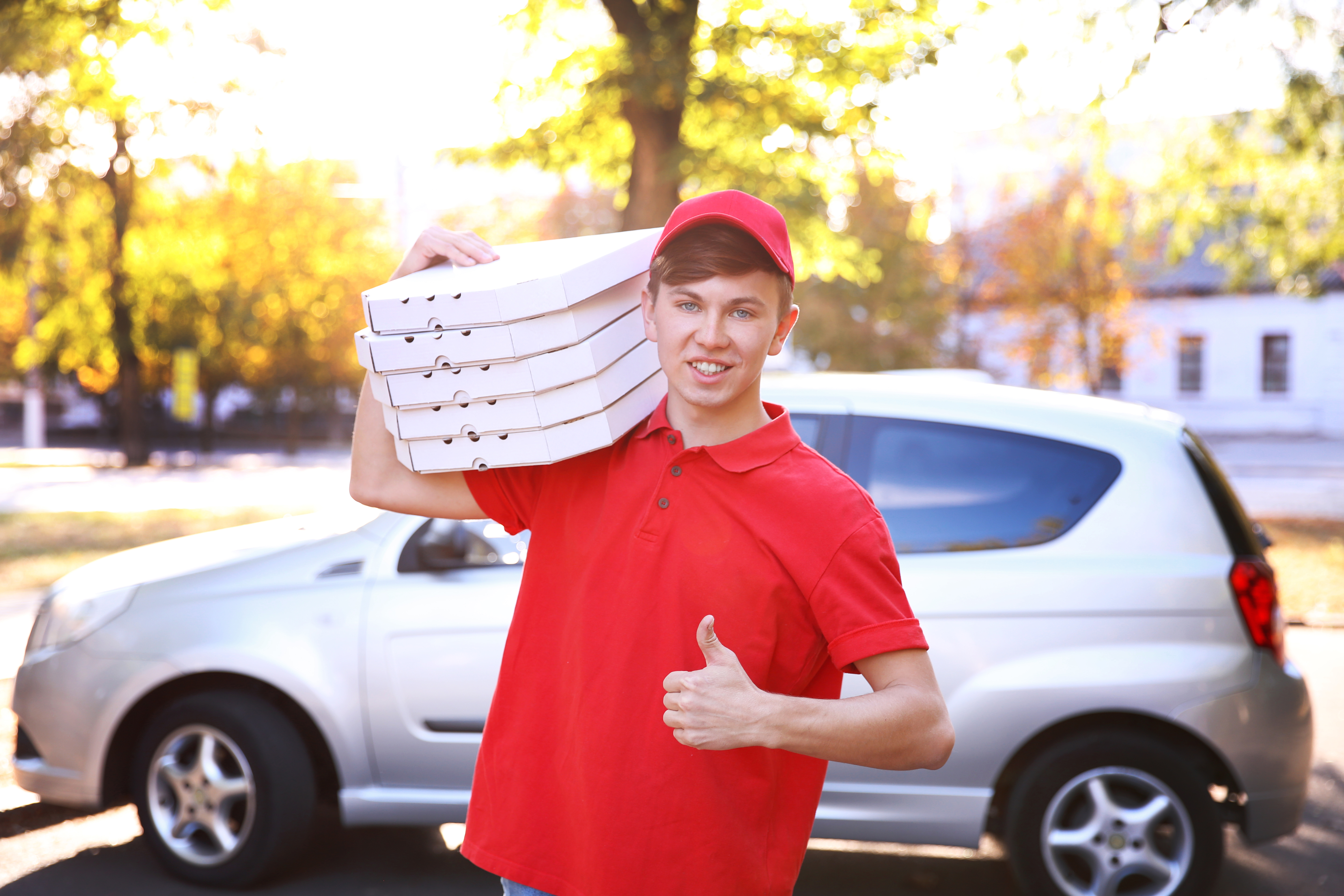 Delivery Pizza boy in a red polo and hat in Cooper City 